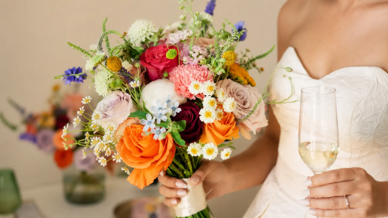 Bride holding a colorful spring wedding bouquet with roses, peonies, chamomile flowers and seasonal blooms Spring Wedding Bouquets
