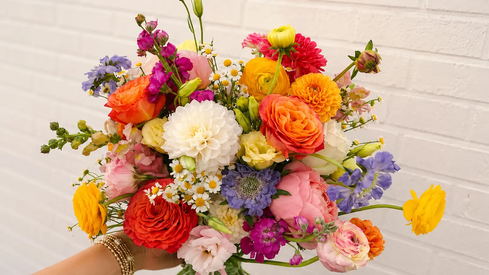 Colorful summer wedding bouquet with garden roses, ranunculus, chamomile and fresh seasonal wildflowers Summer Wedding Bouquets