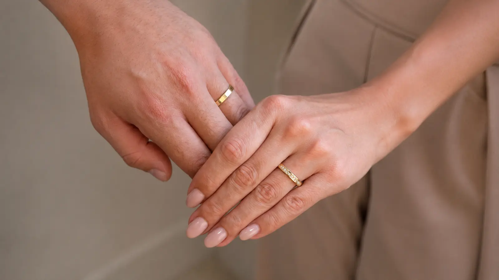 Couple comparing different gold wedding ring options with a jeweler