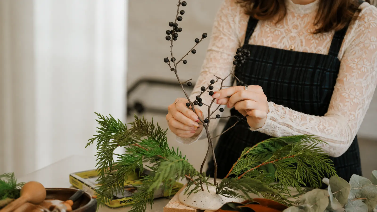 Florist creating a black wedding bouquet with natural foliage and dark accents