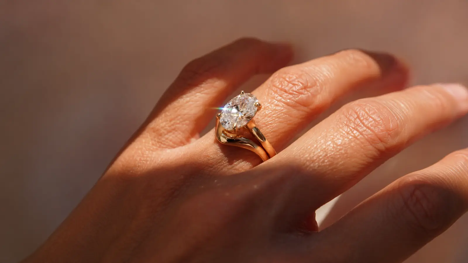 A curved yellow gold wedding band fitted closely against an oval engagement ring for a smooth and elegant bridal stack Wedding Bands for Oval Engagement Rings