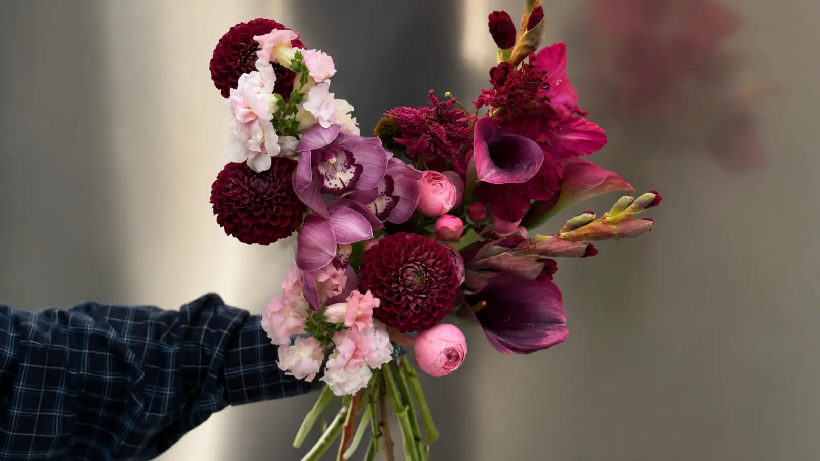 Deep plum purple wedding bouquet with orchids, calla lilies and dramatic seasonal flowers