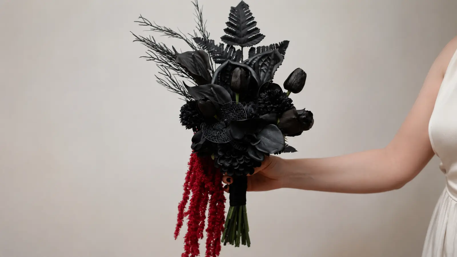 Bride holding a dramatic black wedding bouquet with red amaranthus