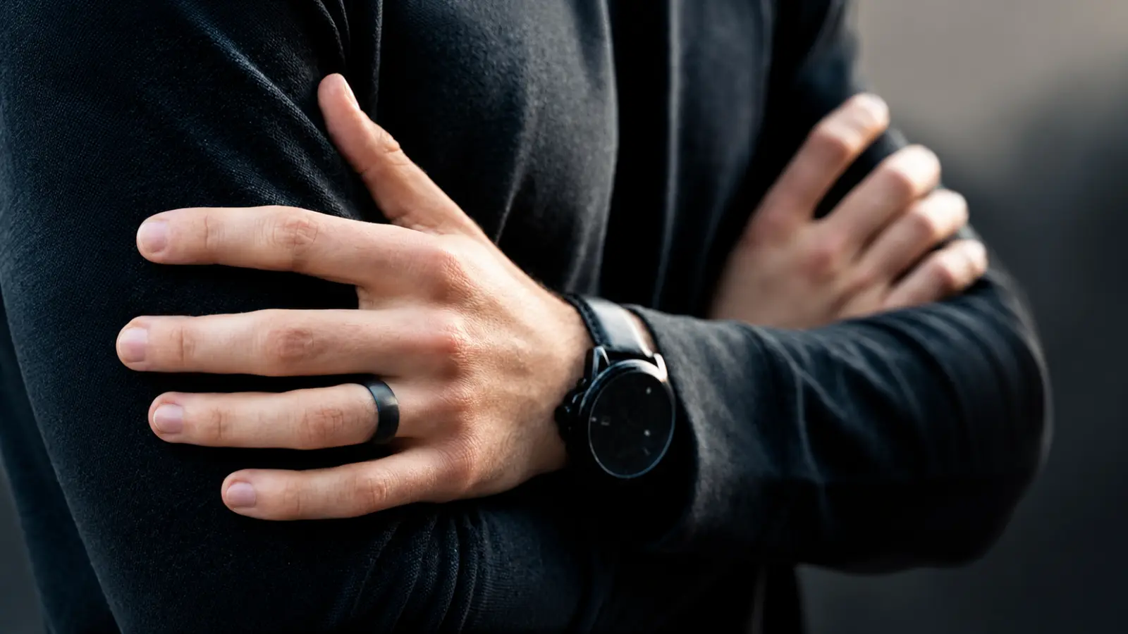 Man wearing a black silicone wedding band with a black wristwatch and casual long-sleeve shirt