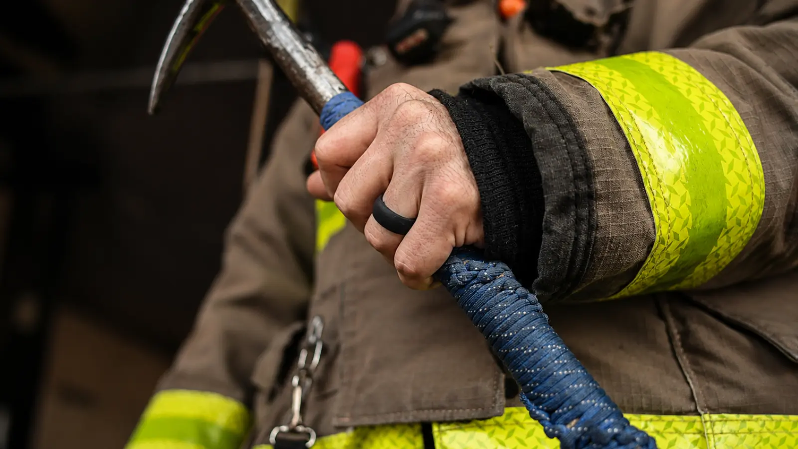 Firefighter gripping equipment while wearing a black silicone wedding band during active duty