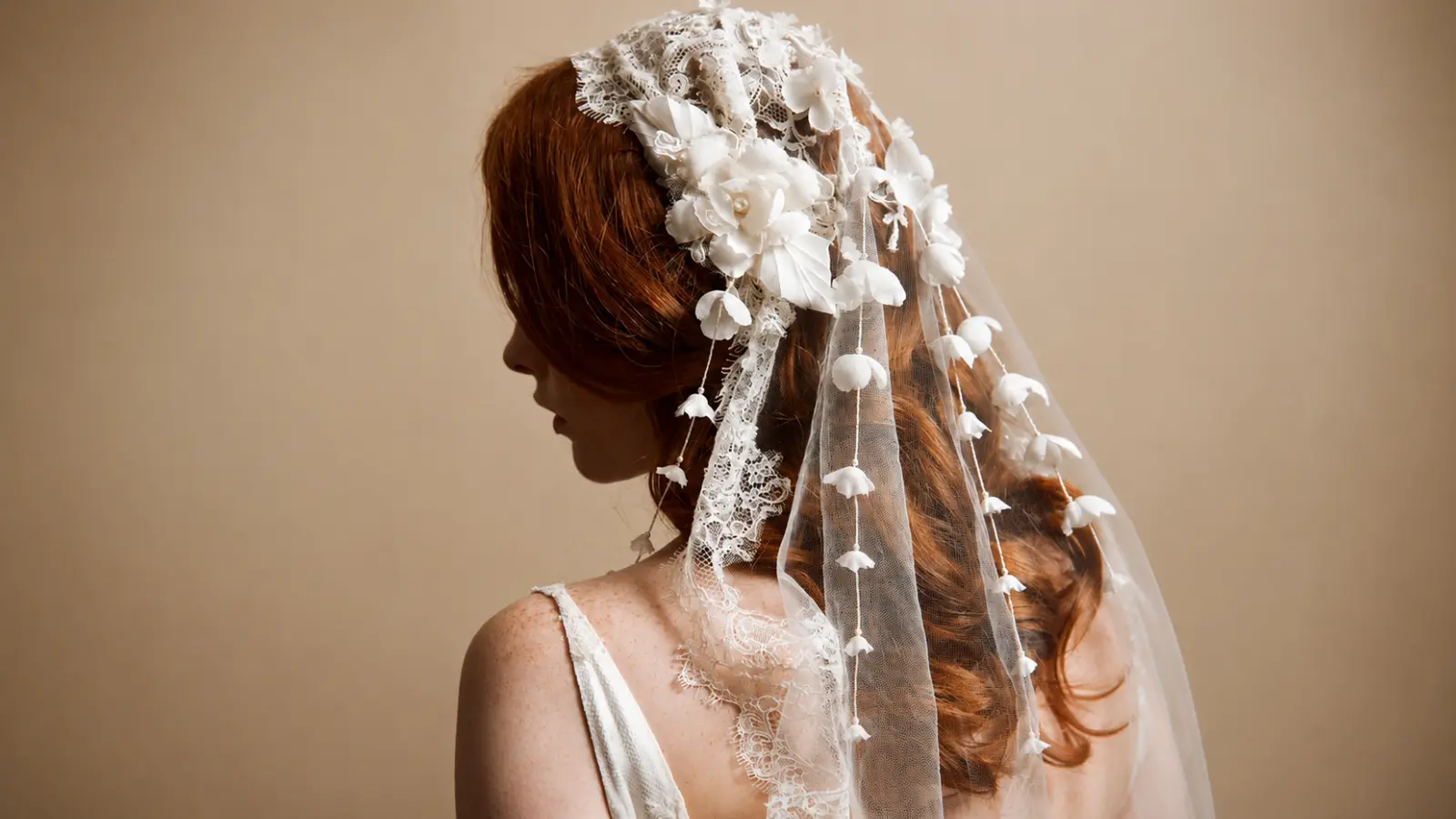 Bride wearing a cathedral wedding veil with floral appliqués and delicate lace embellishments, creating a romantic bridal look with elegant texture and graceful movement