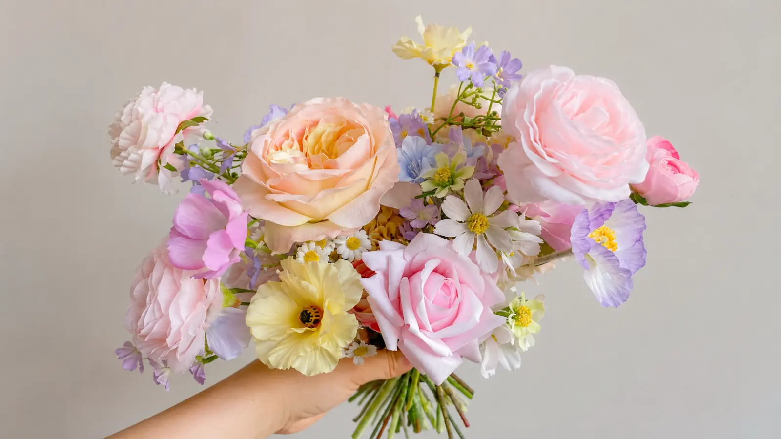 Garden style pastel wedding bouquets with roses, ranunculus and daisies