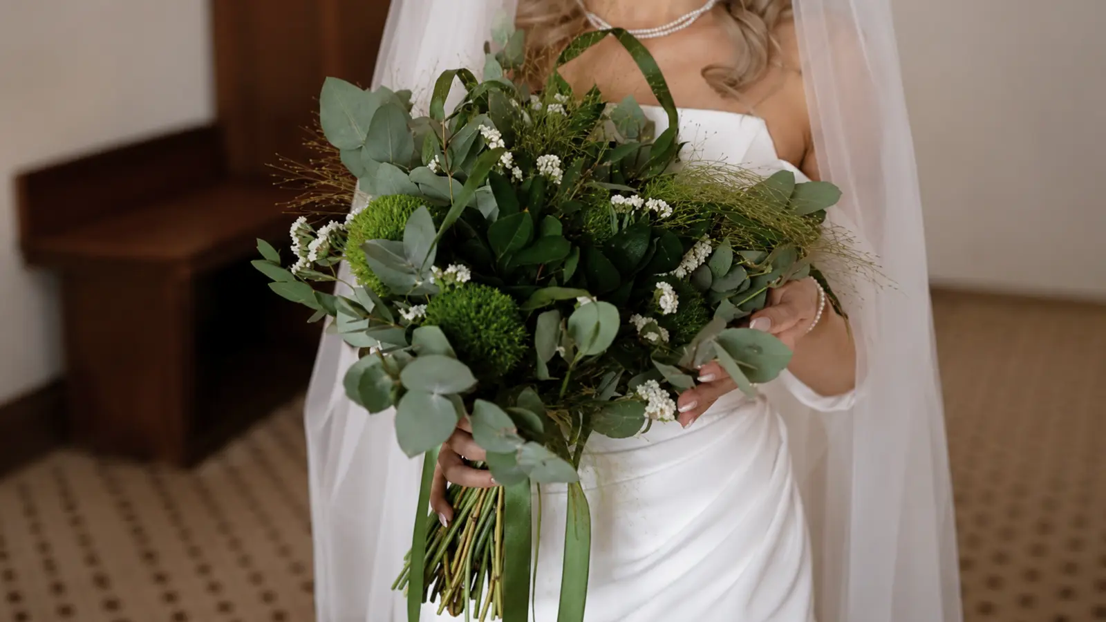 Bride holding a greenery wedding bouquet with eucalyptus and textured foliage