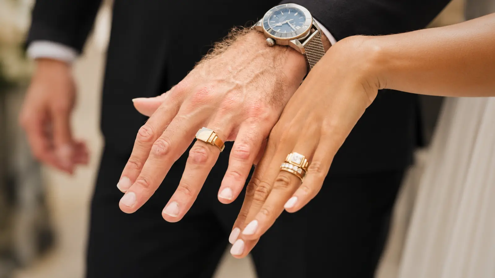 Bride and groom displaying matching gold wedding rings together