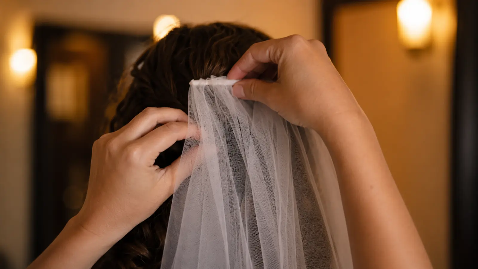 Close-up of hands securing a wedding veil comb into a bride's hairstyle for a stable and comfortable fit
