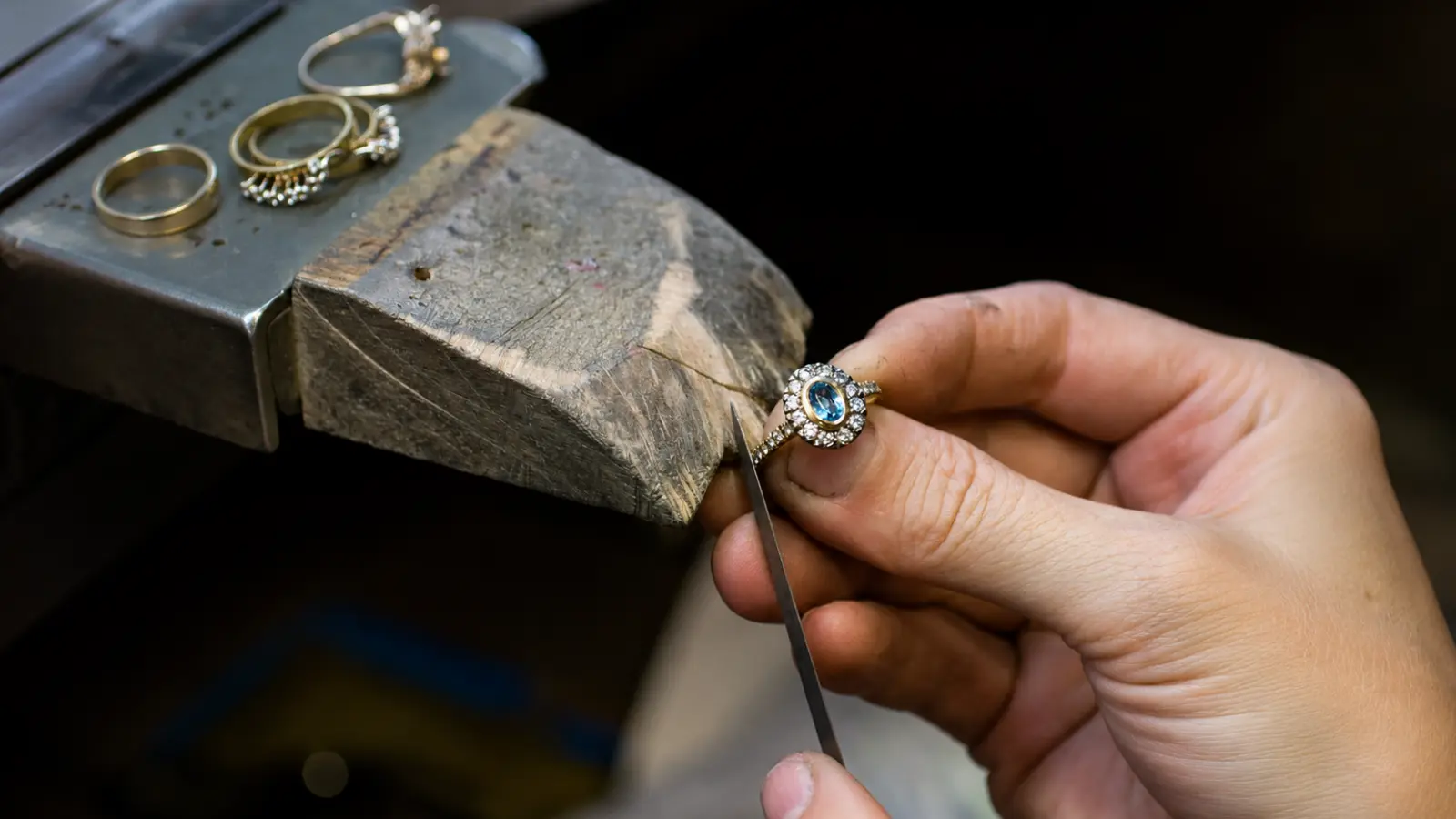 A jeweler examining a gemstone ring after resizing to check the stone setting and overall craftsmanship