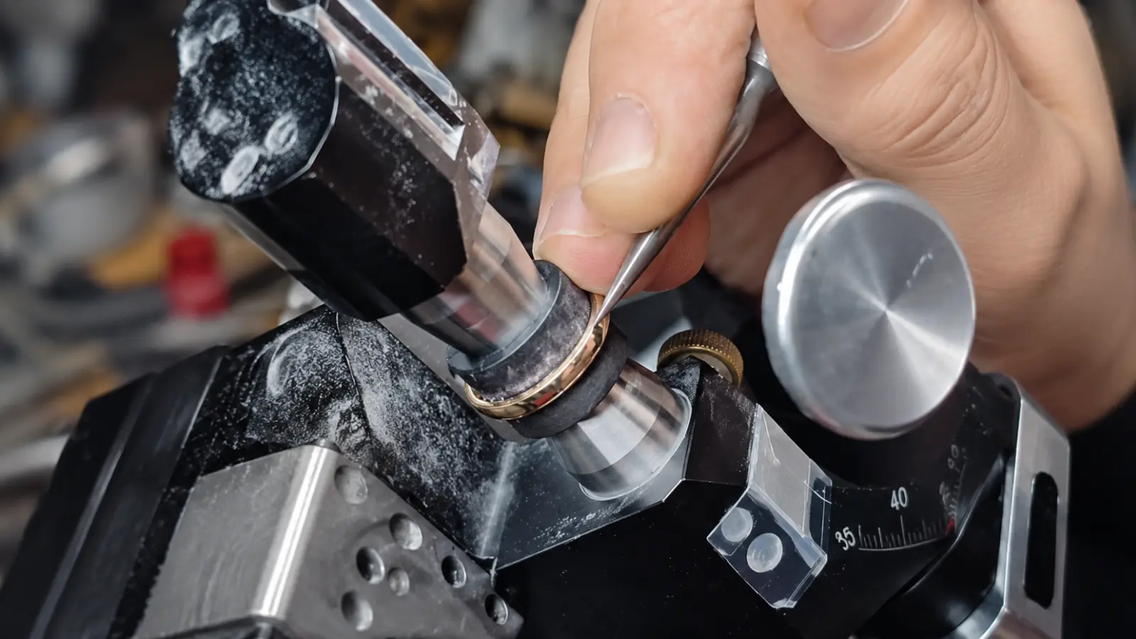 A jeweler crafting a custom wedding ring by hand using professional engraving and shaping equipment at a jewelry workbench