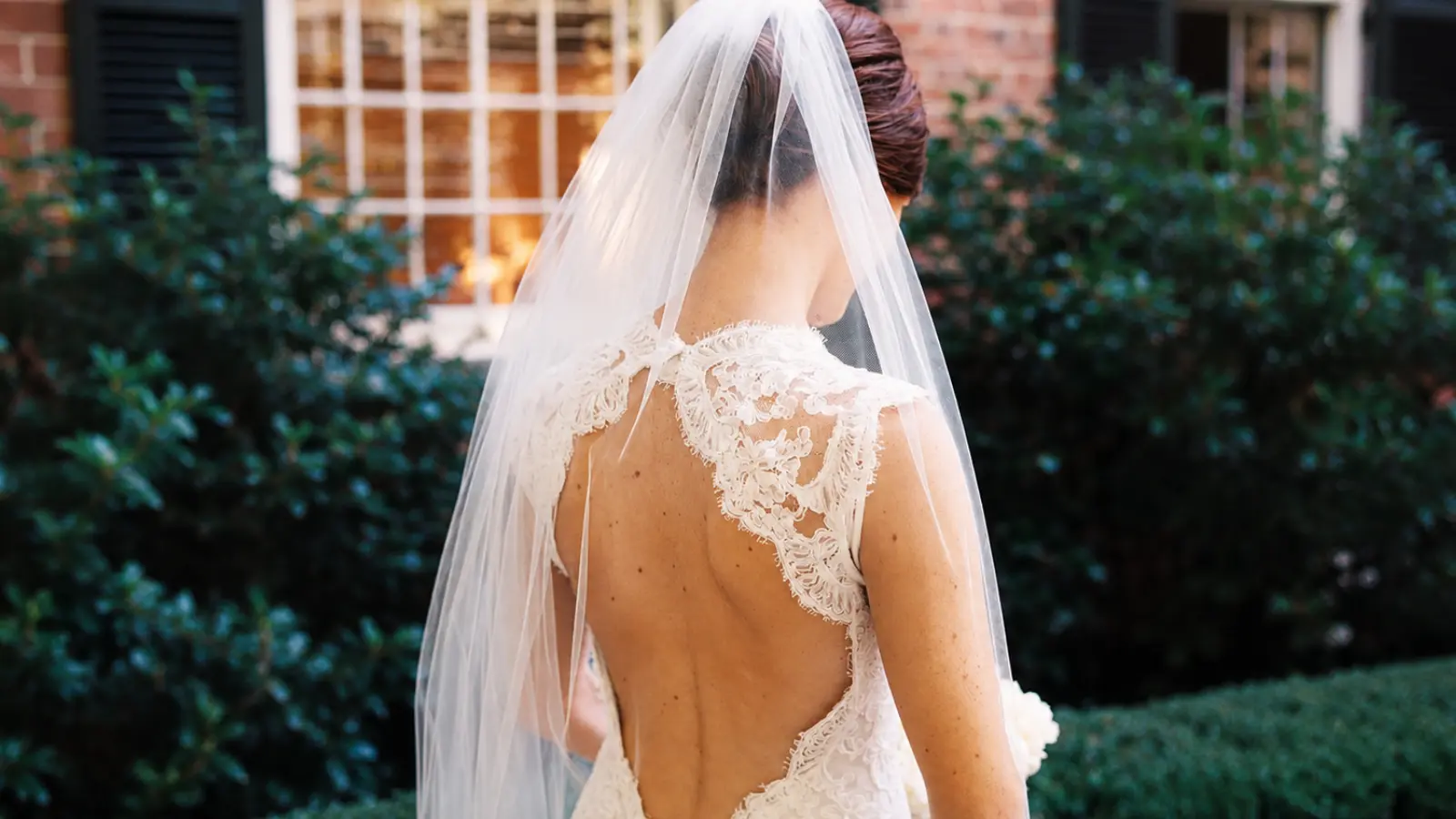 Bride wearing a lace wedding dress with a classic chapel veil, demonstrating a timeless and elegant bridal match