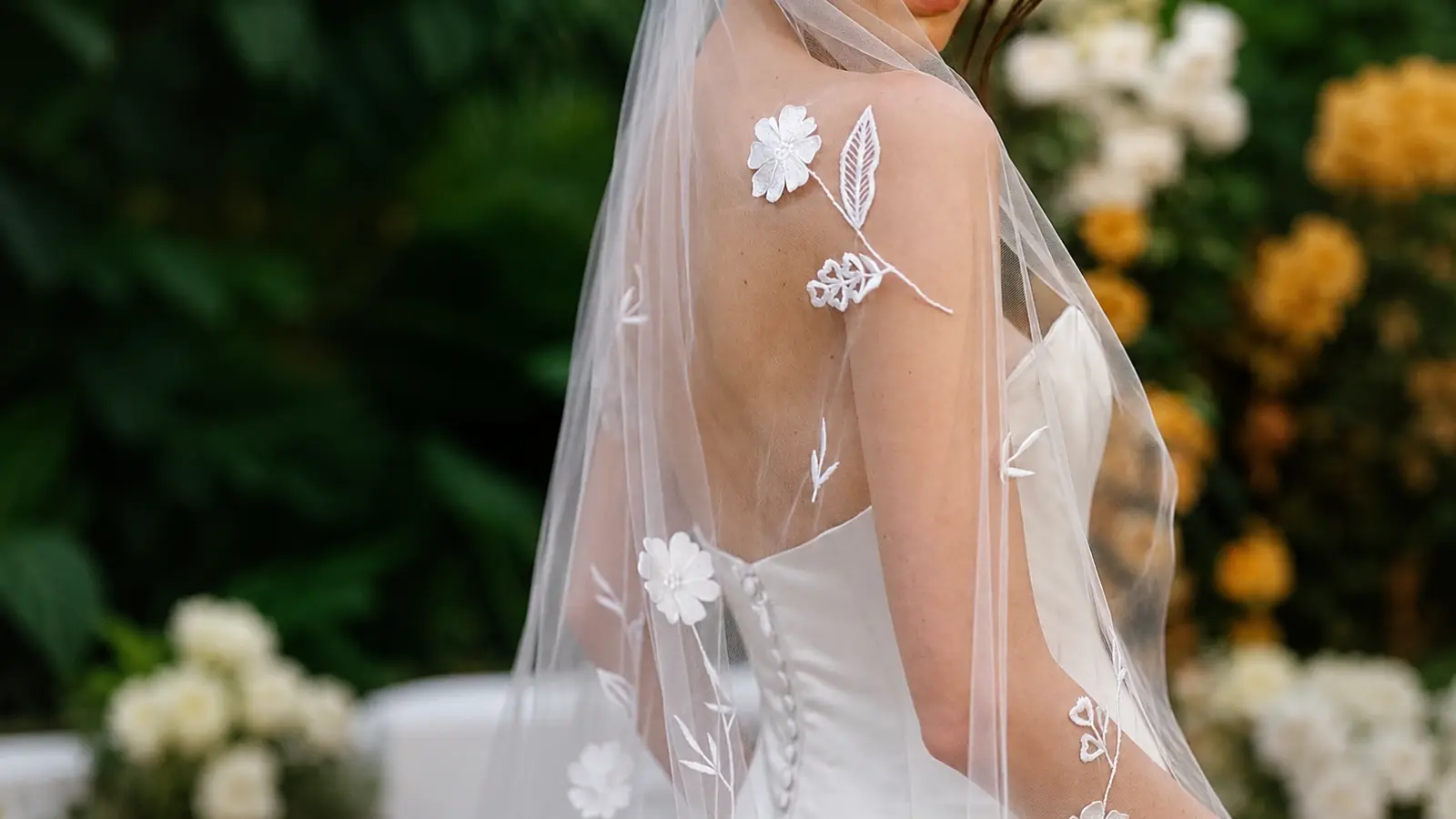 Bride wearing a lace wedding dress with a dotted tulle veil, illustrating a subtle and elegant bridal combination