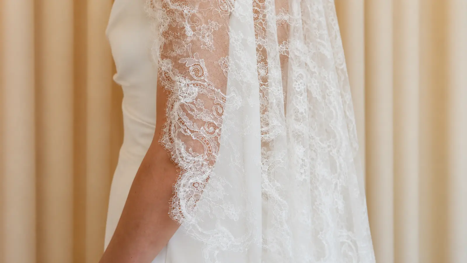 Close-up of a lace wedding veil with intricate floral embroidery and delicate sheer tulle