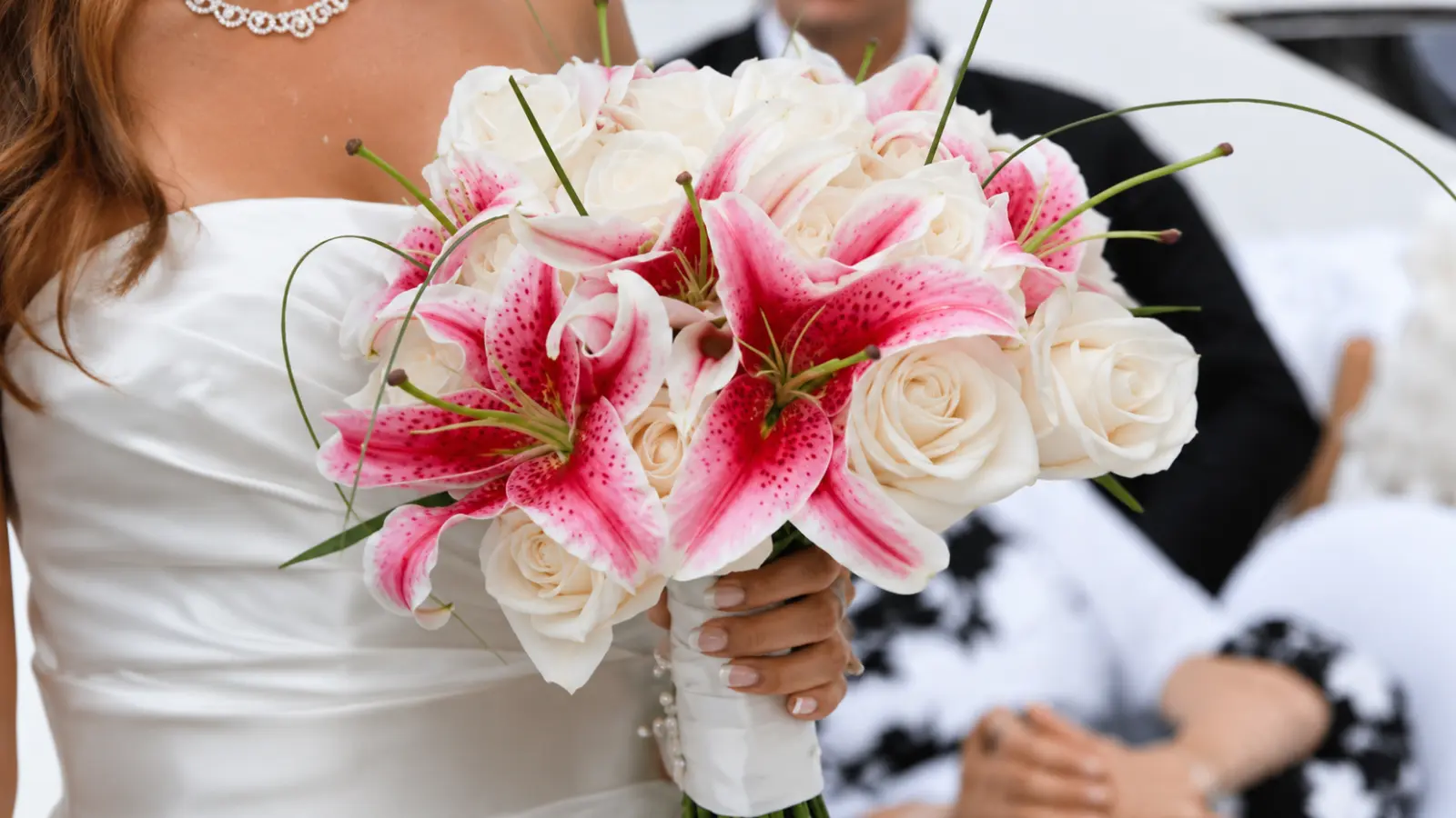 Bridal bouquet combining pink Stargazer lilies, white roses, and elegant decorative greenery