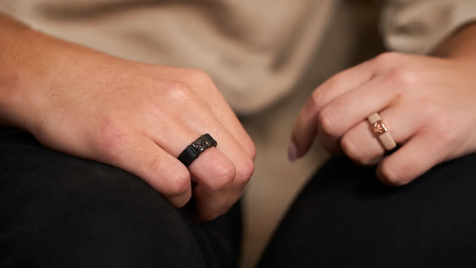 Two people wear matching silicone wedding rings in different colors, highlighting a comfortable and durable alternative to traditional metal wedding bands