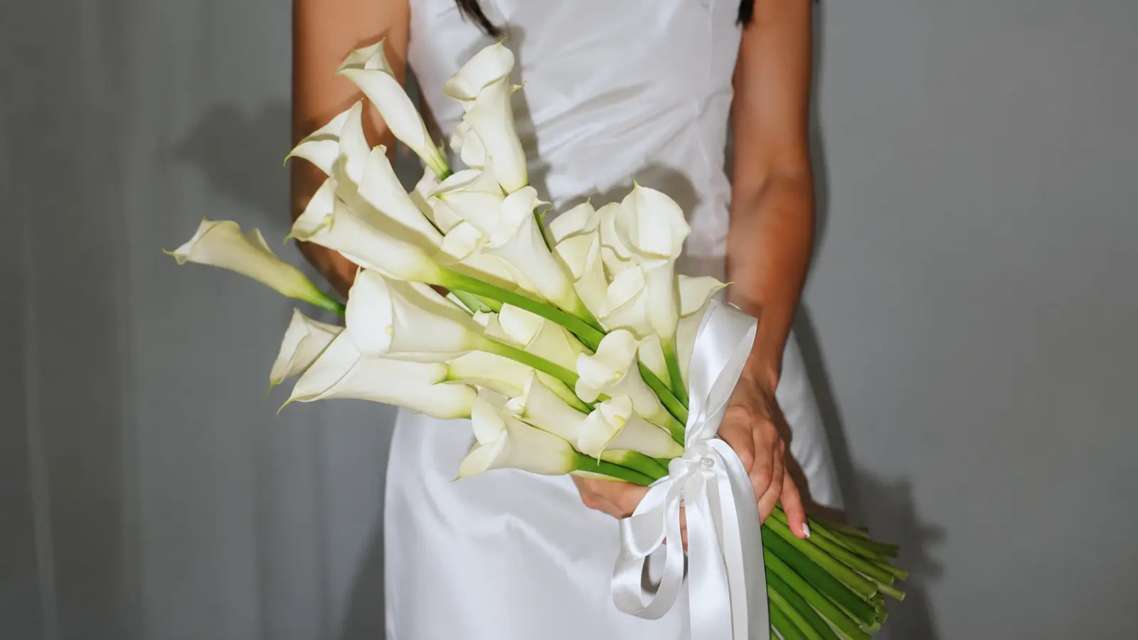 Bride holding a minimalist white calla lily wedding bouquet