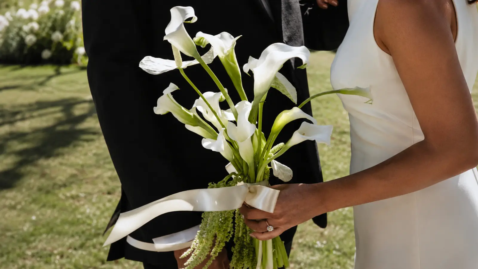Bride holding a modern calla lily bridal bouquet with a satin ribbon
