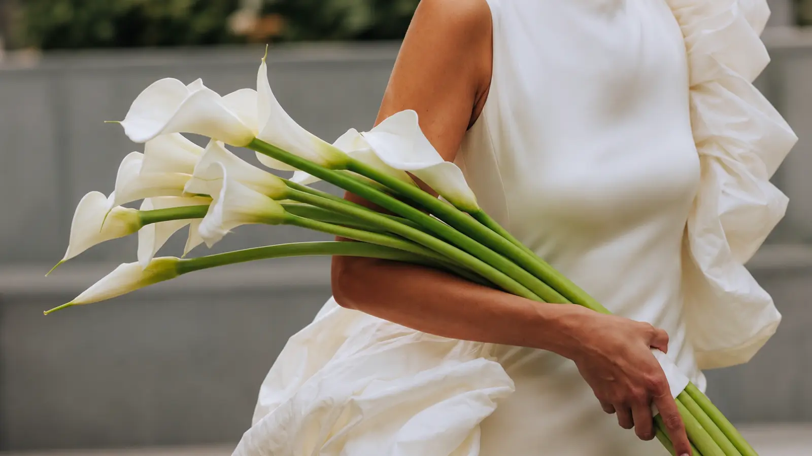 Bride holding a modern wedding bouquet made of white calla lilies