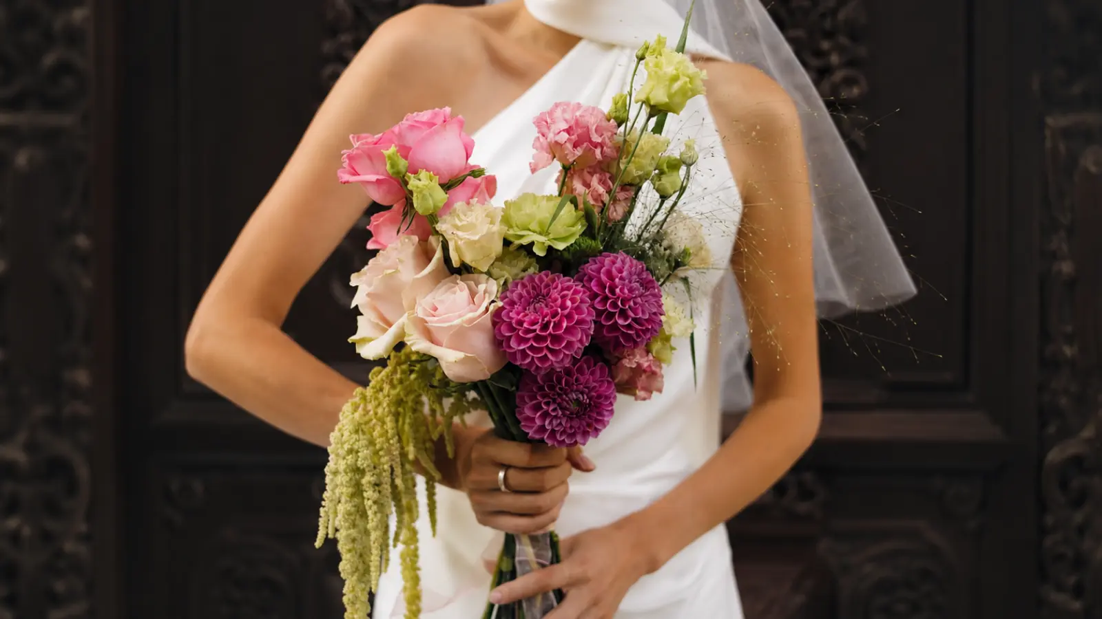 Bride holding a modern sculptural wedding bouquet with dahlias and roses