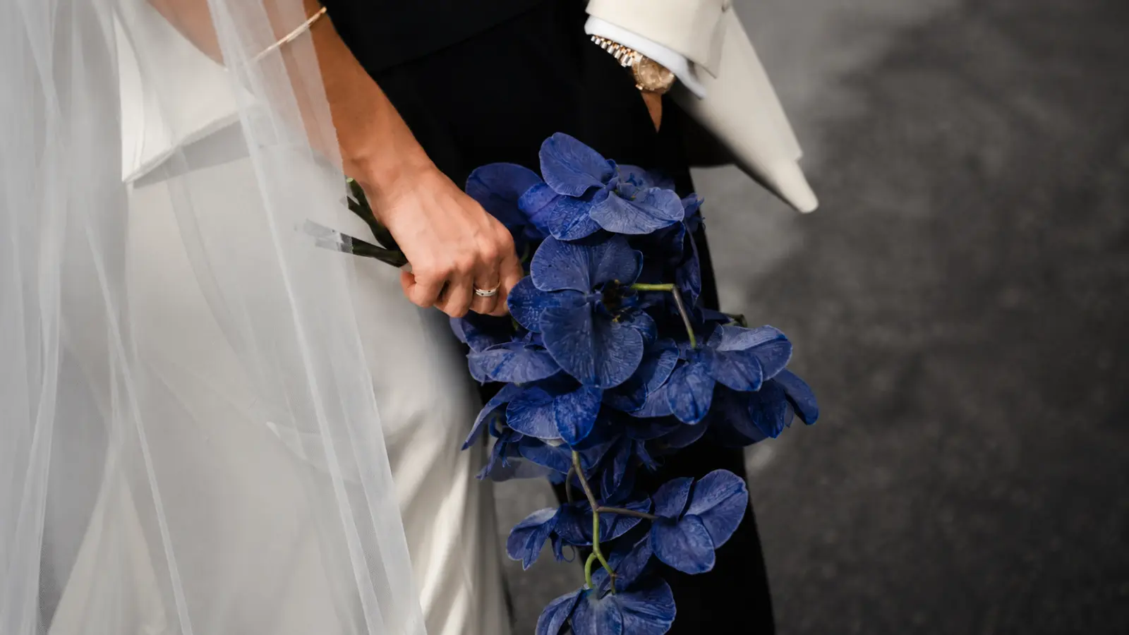 Bride holding a cascading navy blue orchid wedding bouquet
