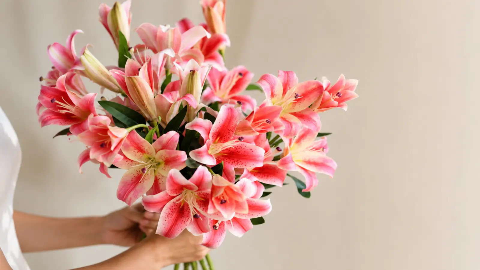 Large arrangement of blooming pink lilies with unopened buds and lush green foliage Lily Wedding Bouquets