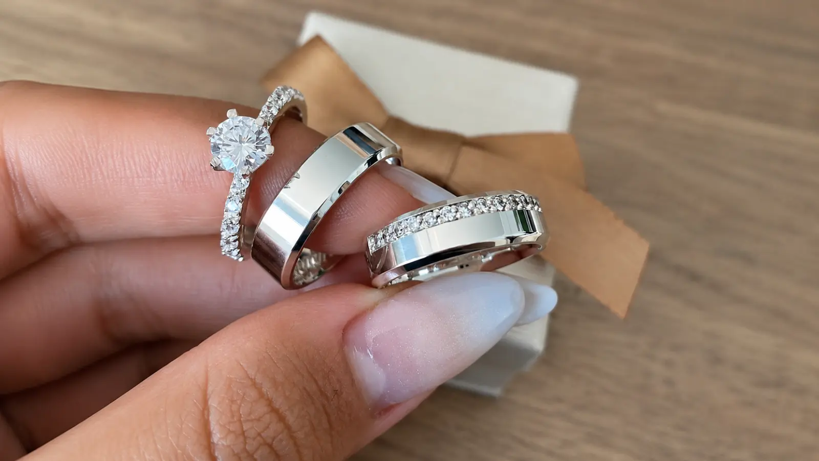 A platinum engagement ring and matching platinum wedding bands are displayed together, showcasing brilliant diamonds, polished finishes and the naturally white color of premium platinum jewelry
