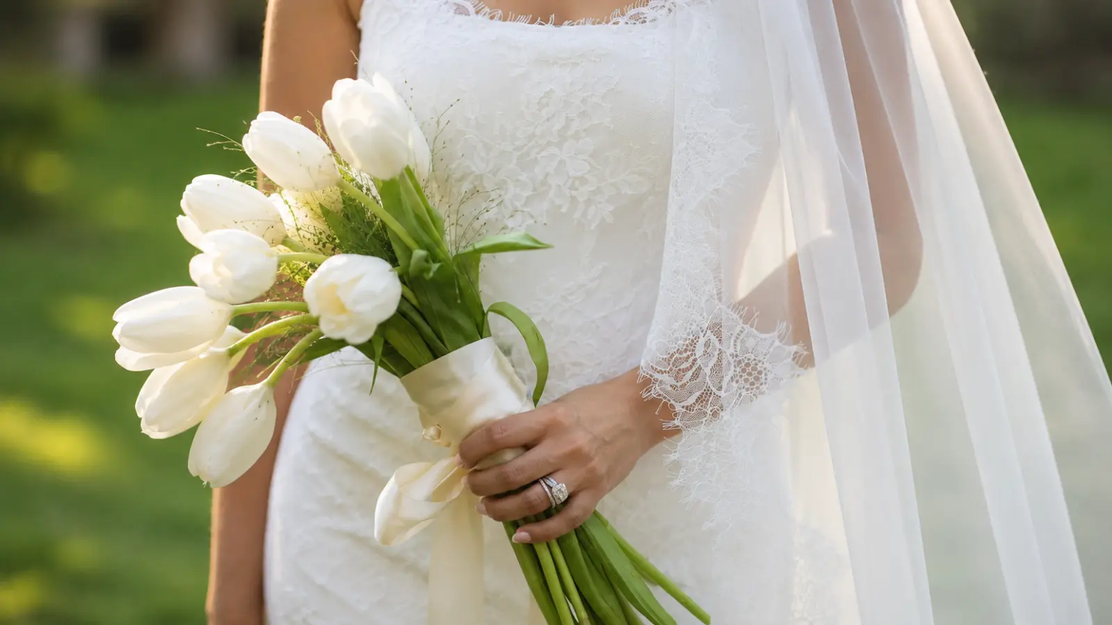 Bride holding a white pomander bridal bouquet with a satin ribbon handle