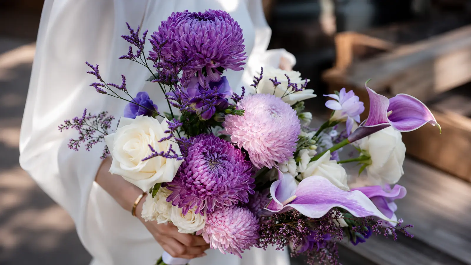 Bride holding a purple wedding bouquet with lavender calla lilies, chrysanthemums and white roses