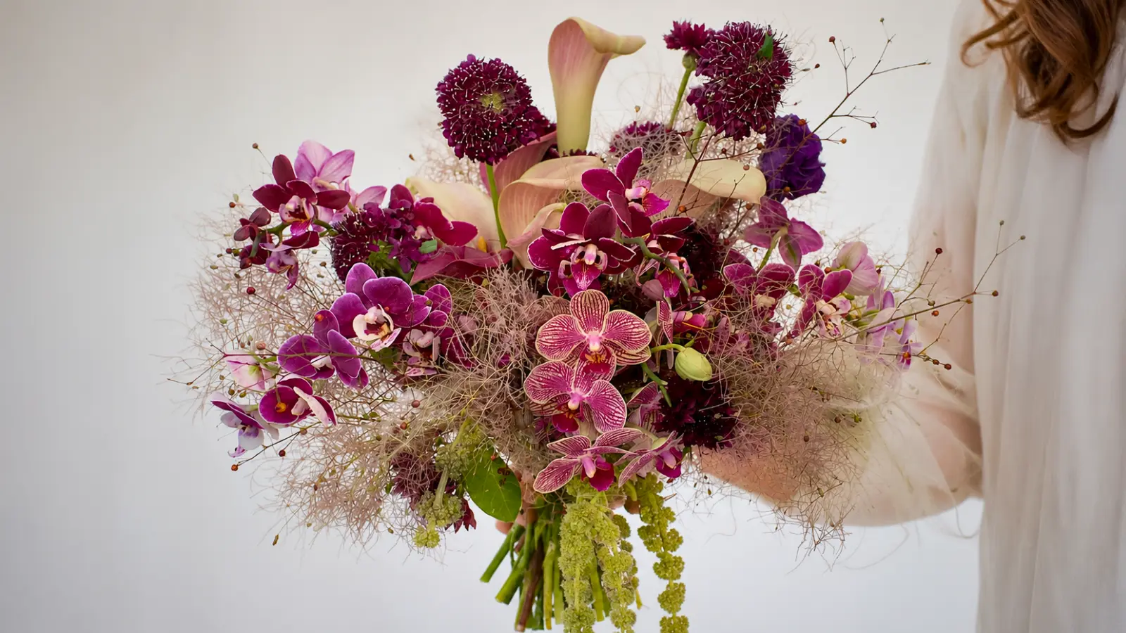 Purple orchid wedding bouquet with smoke bush, calla lilies and cascading greenery