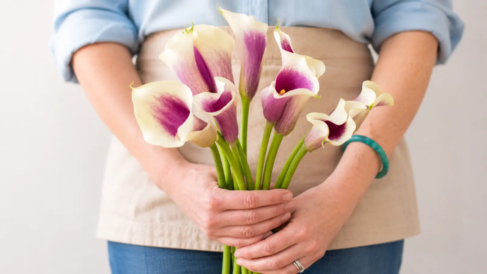 Close-up of fresh purple and white calla lilies arranged together to display different bouquet color options