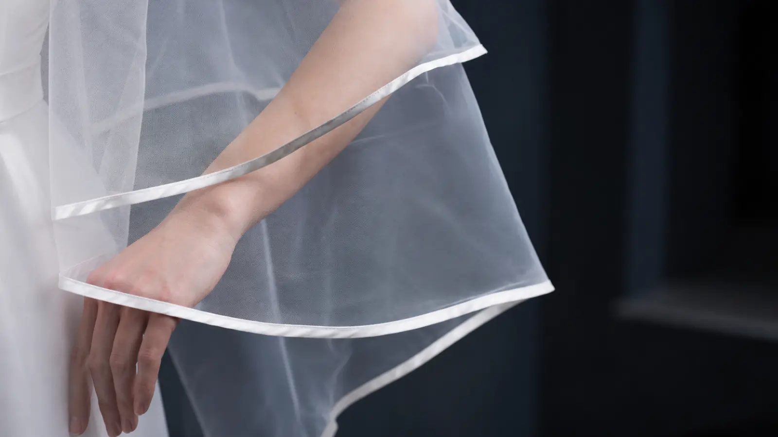 Close-up of a wedding veil with a satin ribbon edge and lightweight tulle fabric