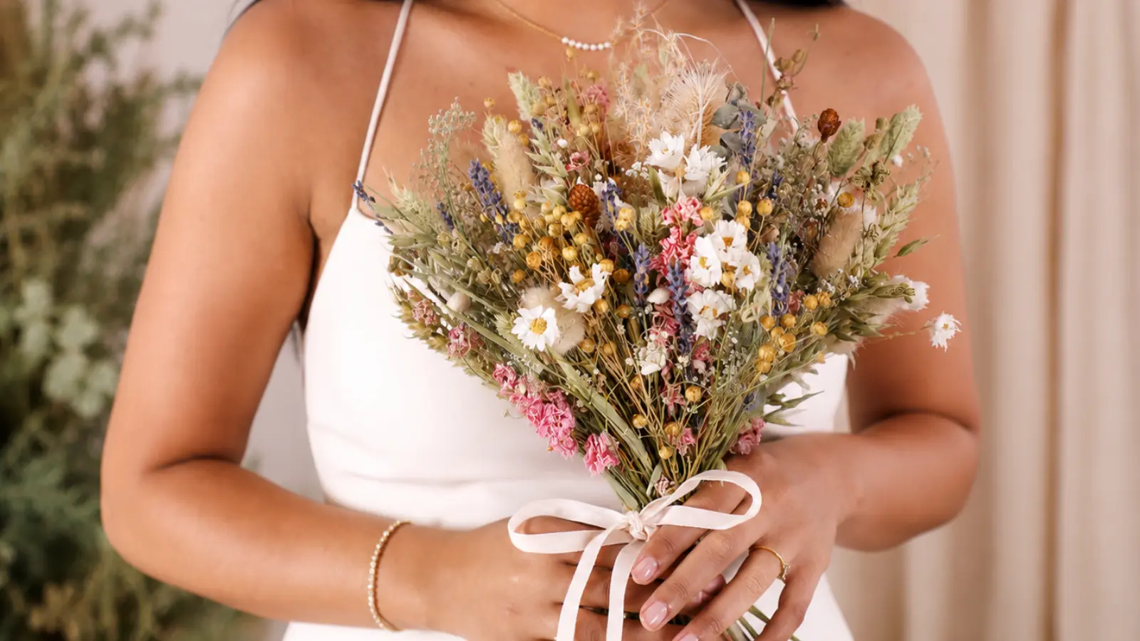 Bride holding a rustic boho dried flower wedding bouquet