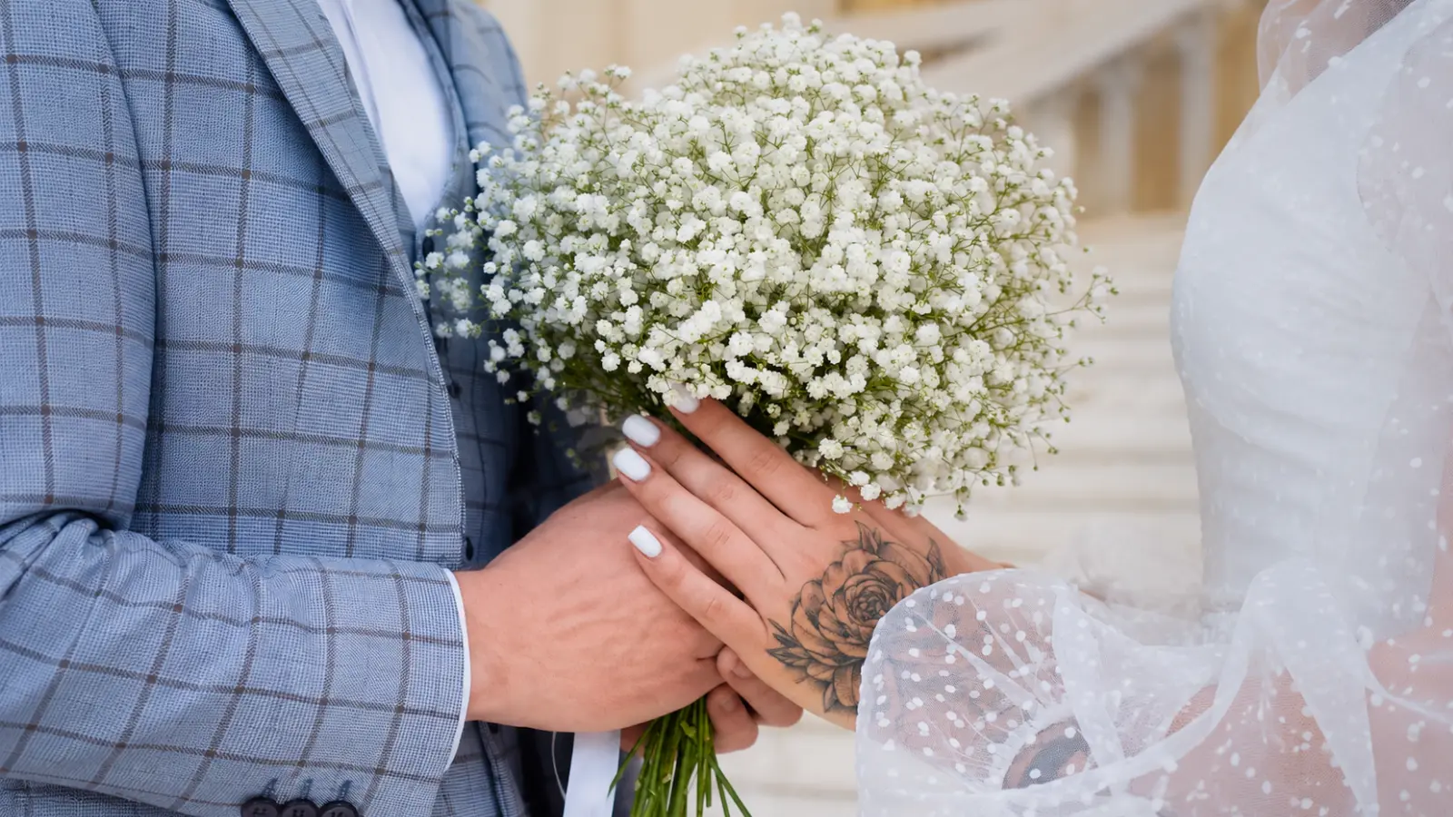 Couple holding a simple Baby's Breath wedding bouquet