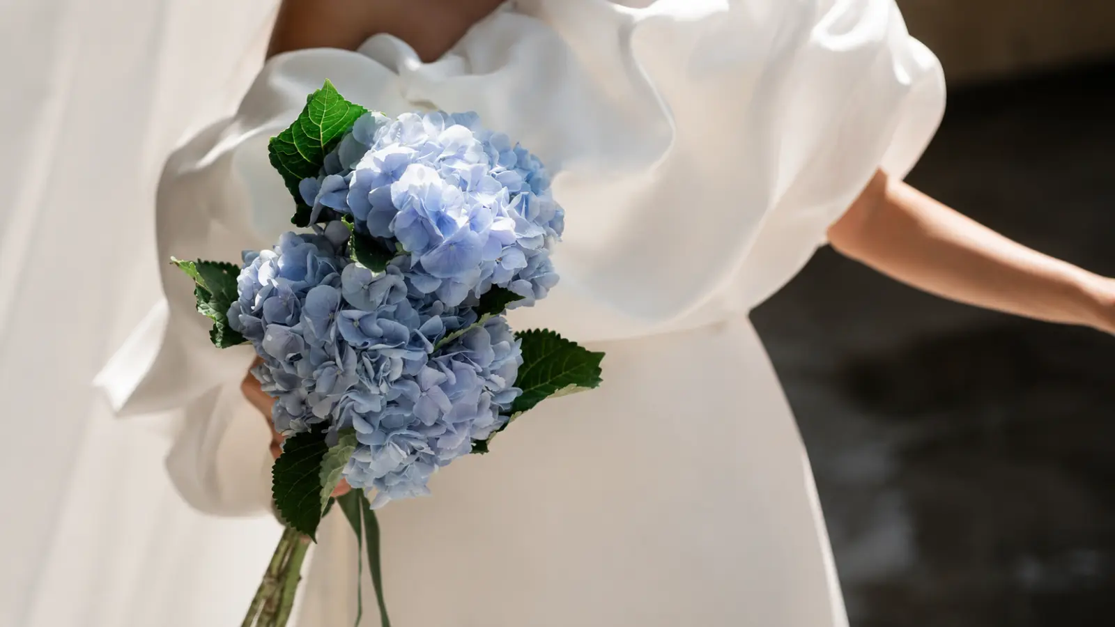 Bride holding a simple blue hydrangea wedding bouquet
