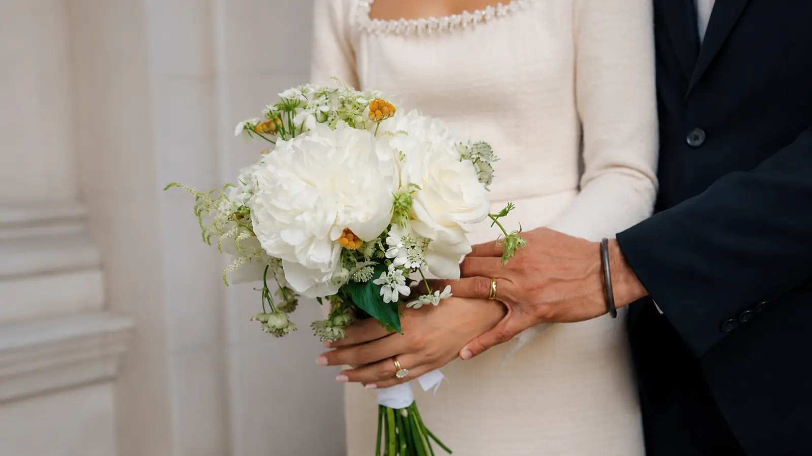 Bride holding a simple white courthouse wedding bouquet with peonies and roses