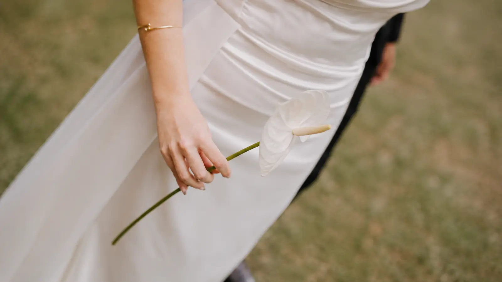 Bride holding a single white anthurium instead of a traditional courthouse wedding bouquet