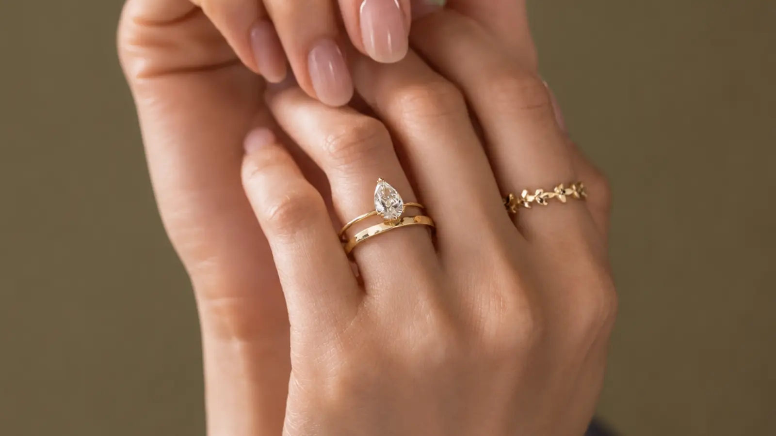 A pear shaped engagement ring paired with a straight gold wedding band on a woman's hand Wedding Bands for Pear Shaped Engagement Rings