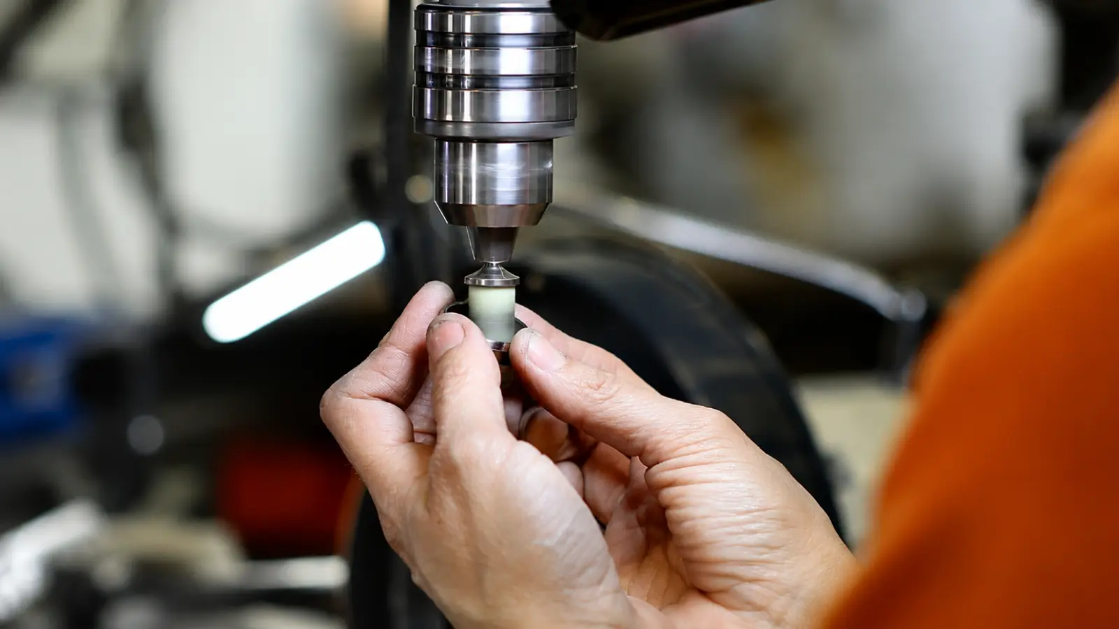 A jeweler carefully machines a tungsten wedding ring using professional equipment, highlighting the precision required to manufacture this exceptionally durable metal