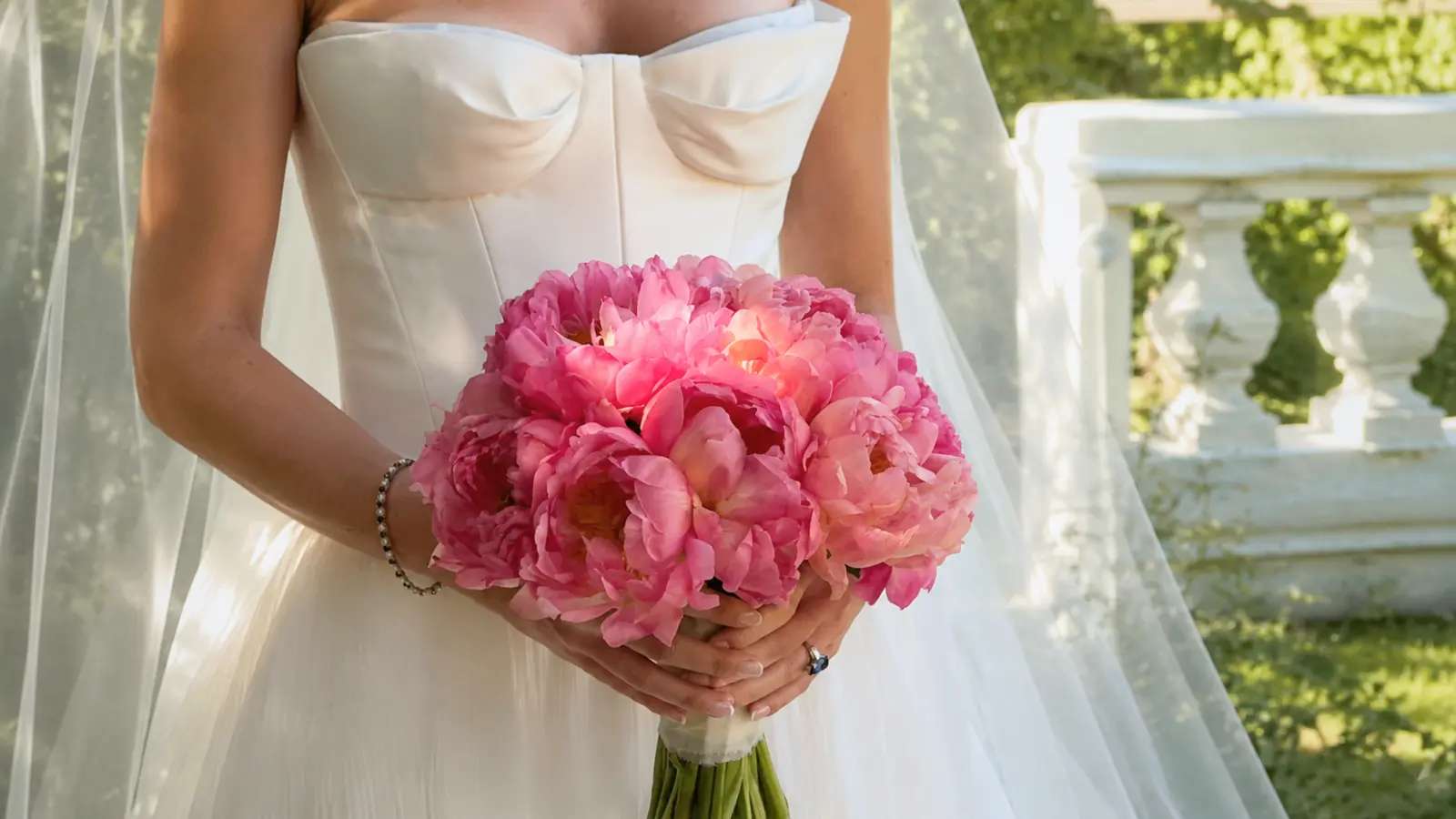 Bride holding a large pink peony wedding bouquet