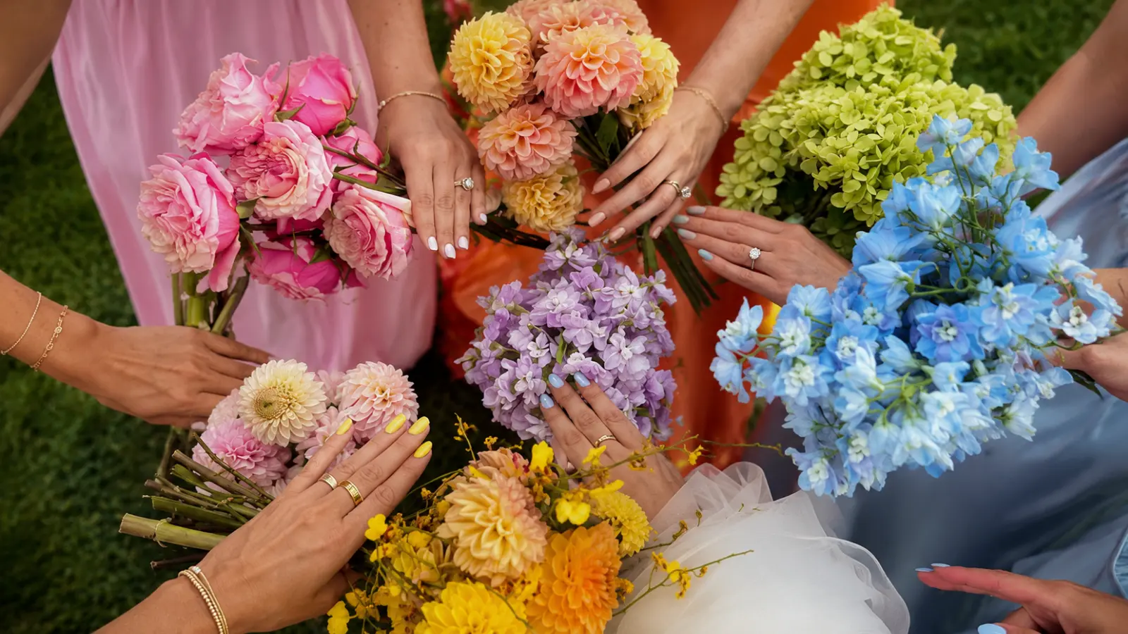 Bridesmaids comparing wedding bouquet color palettes with pink, peach, blue and yellow flowers