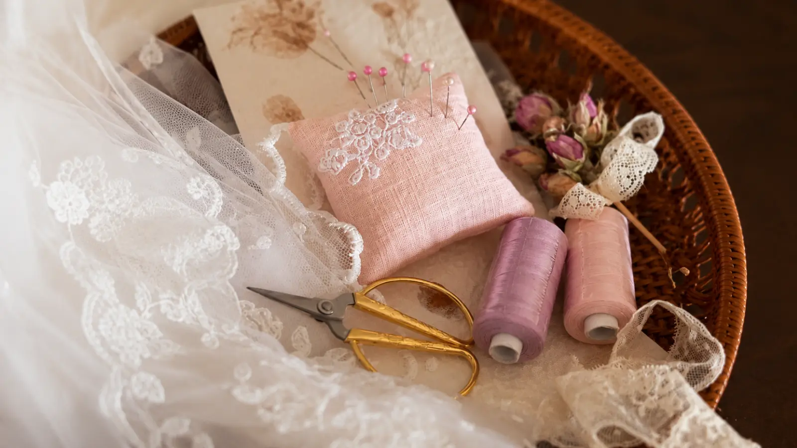 Wedding day sewing supplies with scissors thread pins lace and a pincushion prepared for the bridal emergency kit