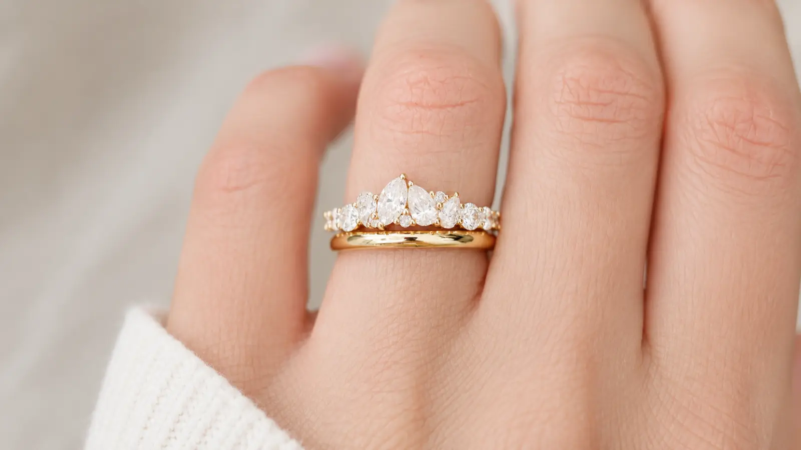 A stacked wedding ring guard with marquise and round diamonds paired with a polished yellow gold wedding band