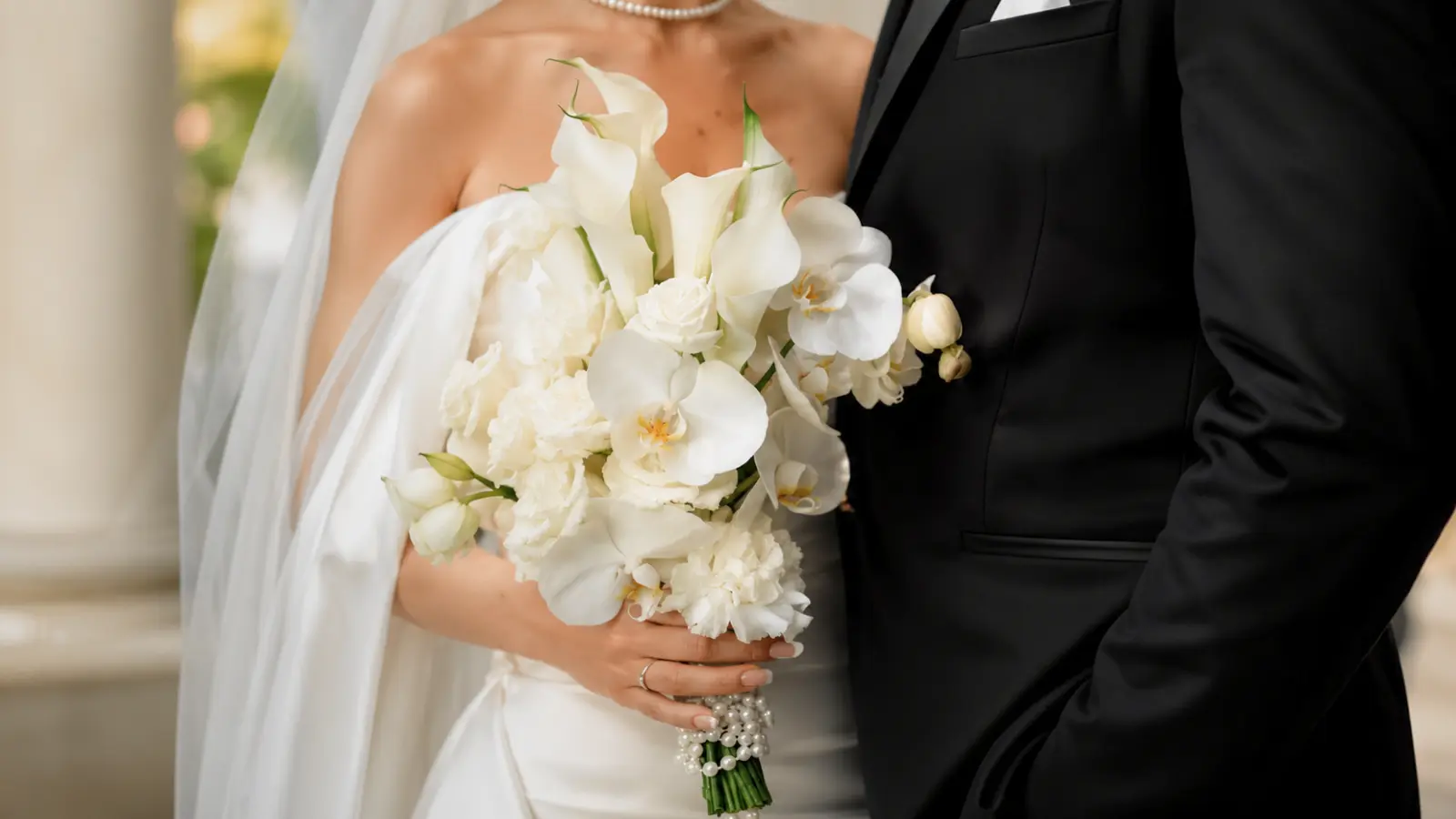 Bride holding a white artificial wedding bouquet with real-touch orchids calla lilies roses and carnations