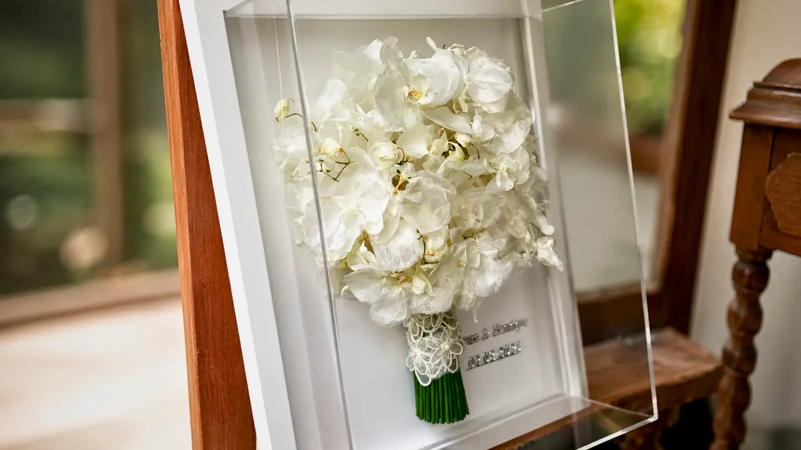 White orchid wedding bouquet preserved inside a deep shadow box with acrylic front and personalized wedding details