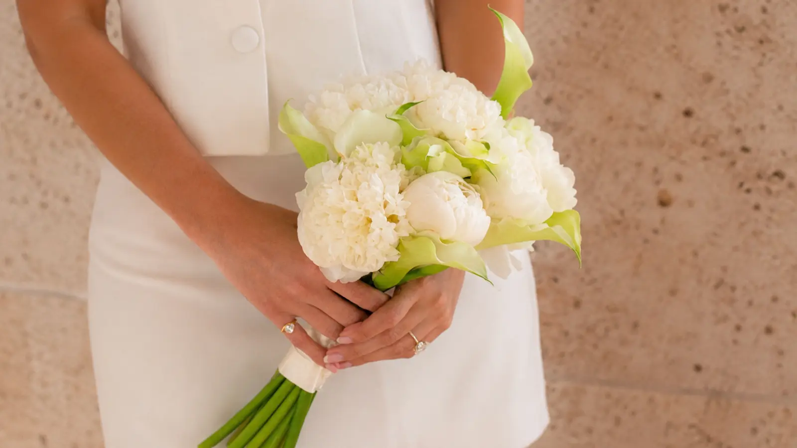 Bride holding a classic white wedding bouquet with calla lilies, peonies and carnations