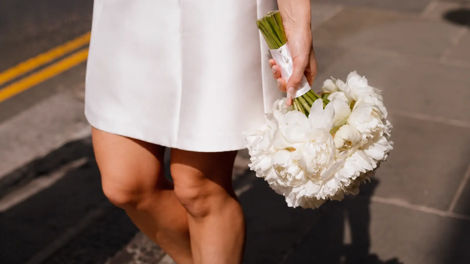 Bride carrying a white peony courthouse wedding bouquet for a city hall ceremony Courthouse Wedding Bouquets