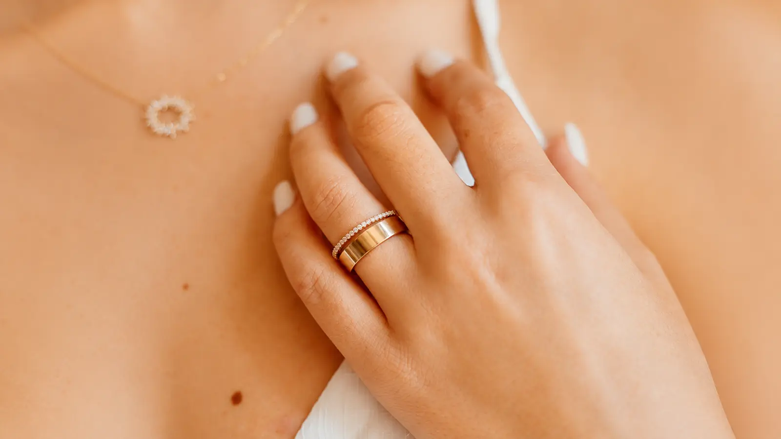 Wide gold engagement ring paired with a slim diamond wedding band