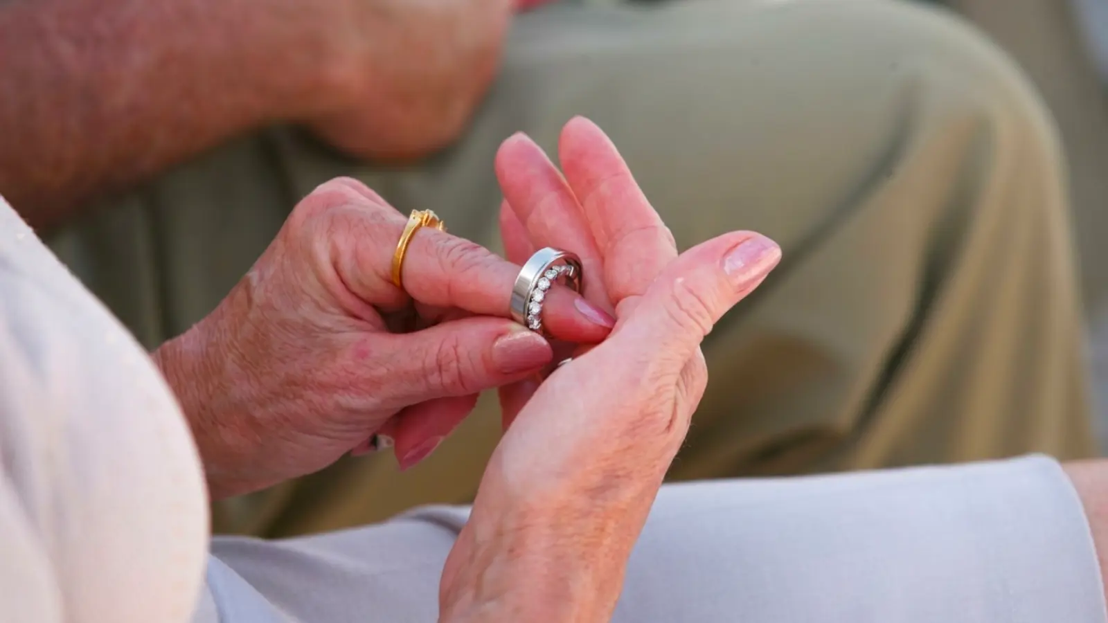 An older woman trying on a diamond anniversary ring to celebrate decades of marriage, showing how couples often choose meaningful jewelry together for a special wedding anniversary